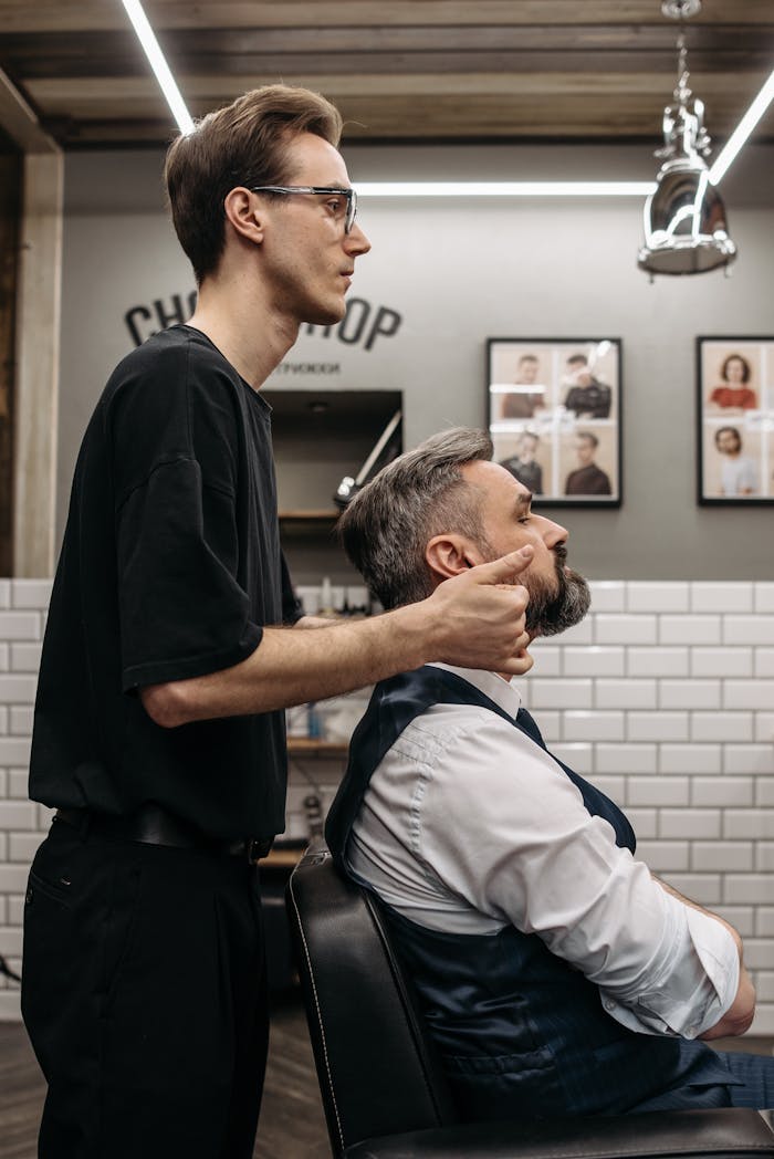 A precise haircut in progress at a contemporary barbershop, featuring a barber and client.